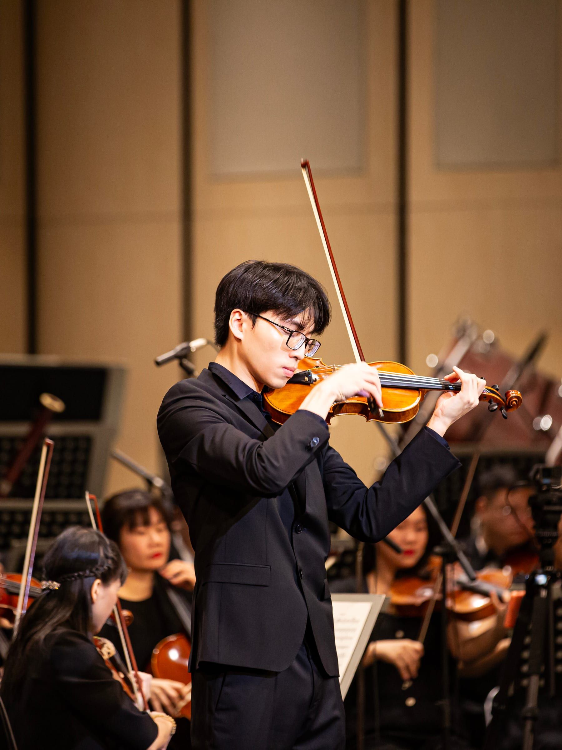 Trần Lê Quang Tiến performing violin with the Saigon Philharmonic Orchestra
